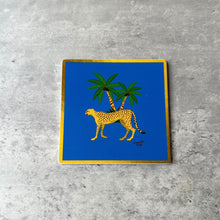 Load image into Gallery viewer, Blue coaster with cheetah walking and a palm plant 

