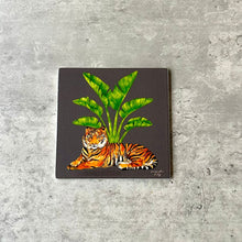 Load image into Gallery viewer, Grey coaster with a tiger and large plant and tree
